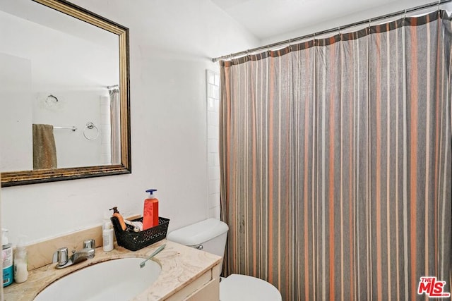 bathroom featuring walk in shower, vanity, and toilet