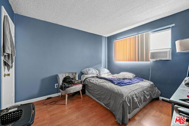 bedroom featuring a textured ceiling and hardwood / wood-style floors