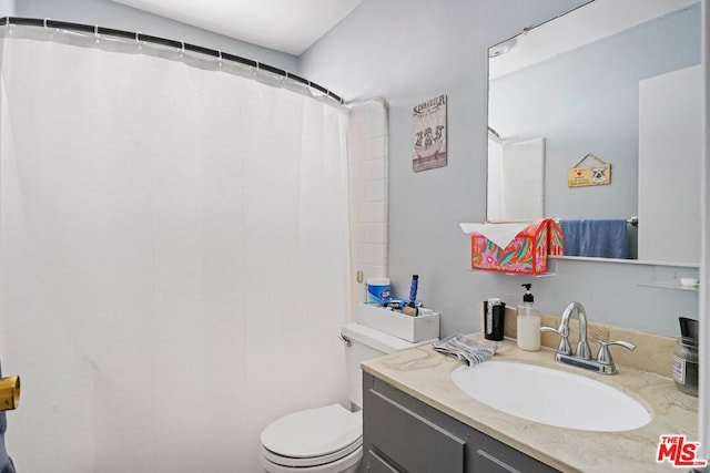 bathroom featuring vanity, toilet, and a shower with shower curtain