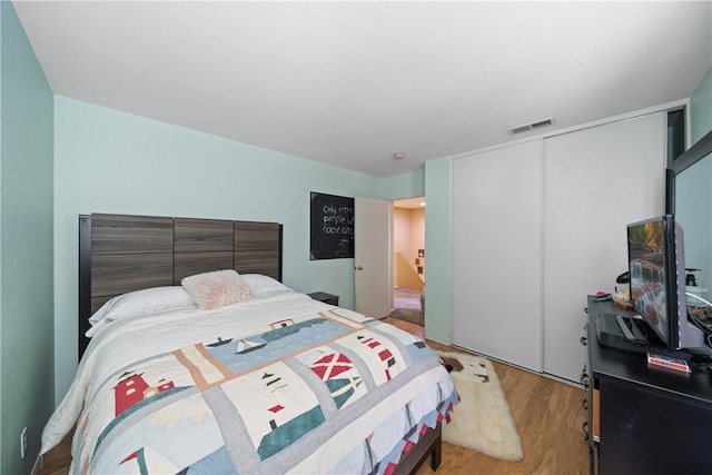 bedroom with light wood-type flooring and a closet