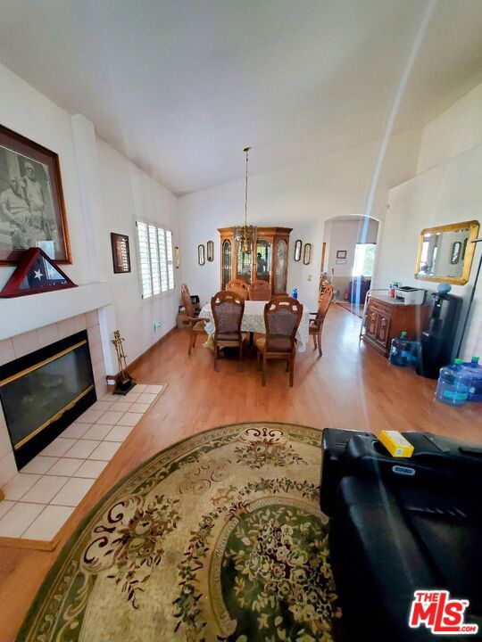 living room with a fireplace, a chandelier, and light wood-type flooring