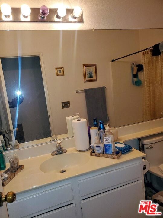 bathroom featuring vanity, a shower with shower curtain, and toilet