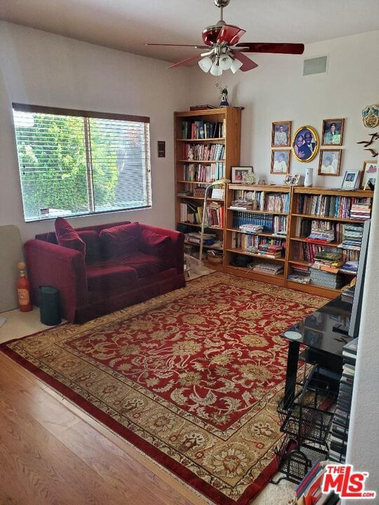 sitting room with hardwood / wood-style floors and ceiling fan