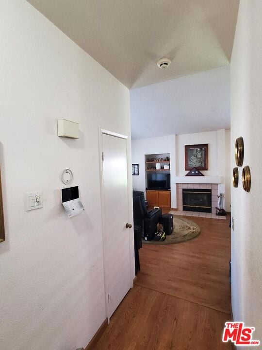 corridor featuring vaulted ceiling and hardwood / wood-style flooring