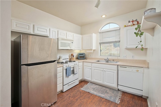 kitchen with white appliances, white cabinetry, sink, and dark wood-type flooring