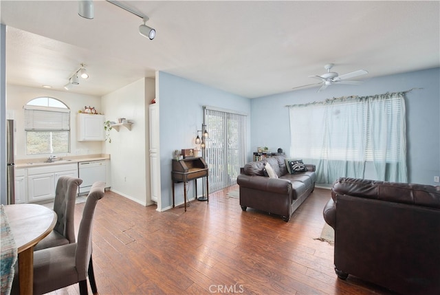 living room featuring ceiling fan, track lighting, dark hardwood / wood-style floors, and sink