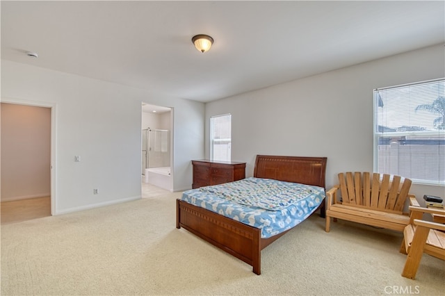 bedroom featuring light colored carpet and ensuite bathroom