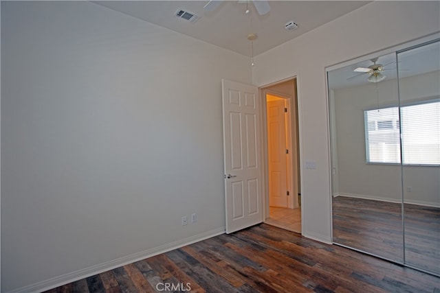 unfurnished bedroom featuring a closet, ceiling fan, and dark wood-type flooring