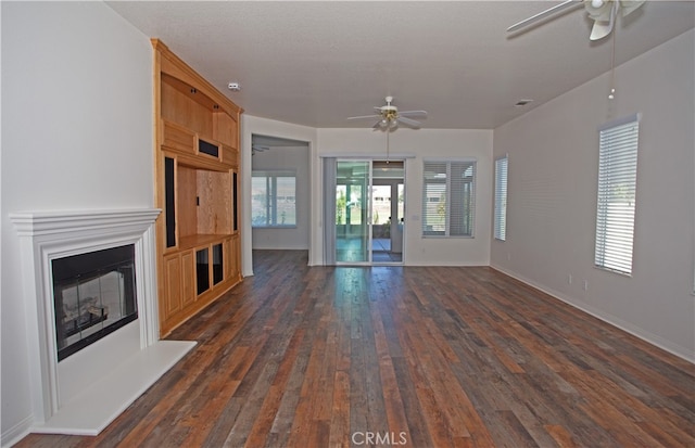 unfurnished living room with ceiling fan and dark hardwood / wood-style flooring