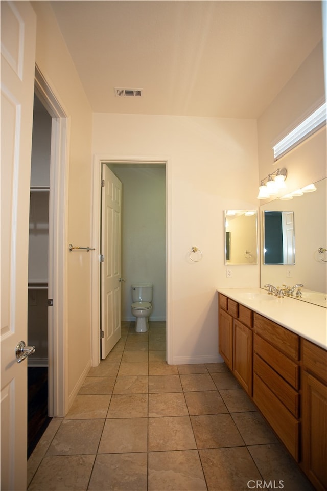 bathroom featuring tile patterned flooring, vanity, and toilet