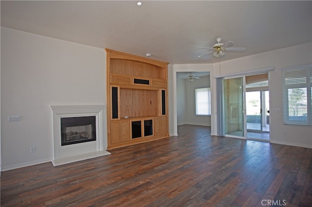 unfurnished living room with ceiling fan and dark wood-type flooring