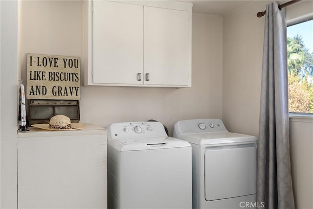 laundry room with washing machine and dryer and cabinets