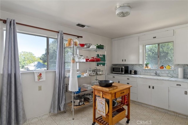 kitchen featuring white cabinetry, tasteful backsplash, and sink