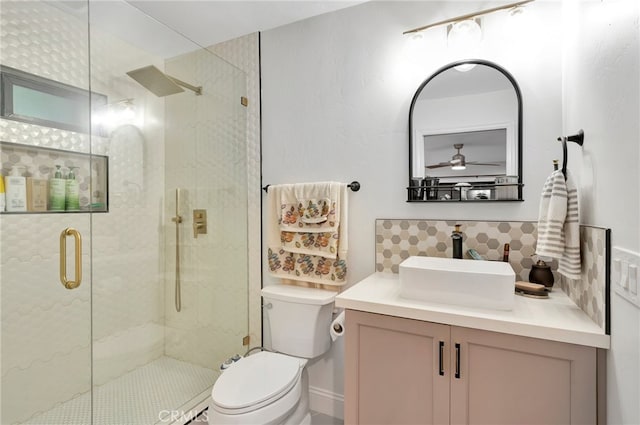 bathroom featuring vanity, toilet, ceiling fan, and an enclosed shower