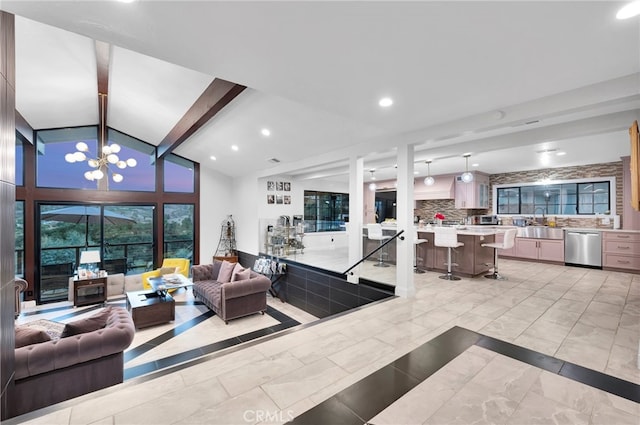 living room featuring an inviting chandelier, beamed ceiling, sink, and high vaulted ceiling