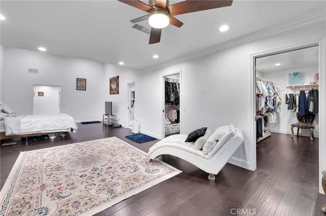 bedroom with dark hardwood / wood-style floors, a spacious closet, ceiling fan, and a closet