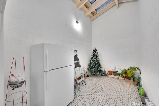 miscellaneous room featuring vaulted ceiling with beams