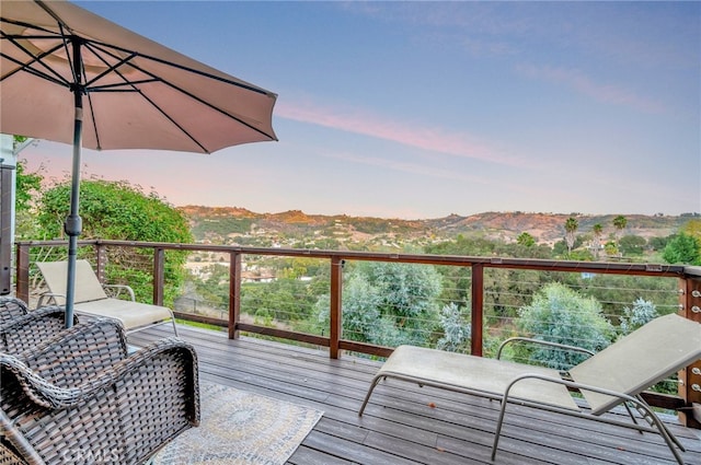 deck at dusk featuring a mountain view