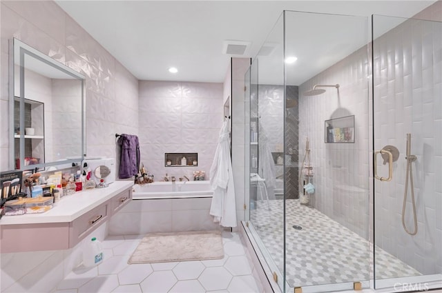 bathroom featuring tile walls, vanity, separate shower and tub, and tile patterned floors