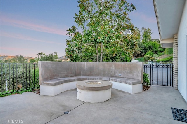 patio terrace at dusk featuring an outdoor fire pit