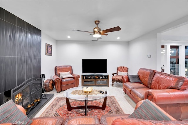 living room with ceiling fan and a wood stove