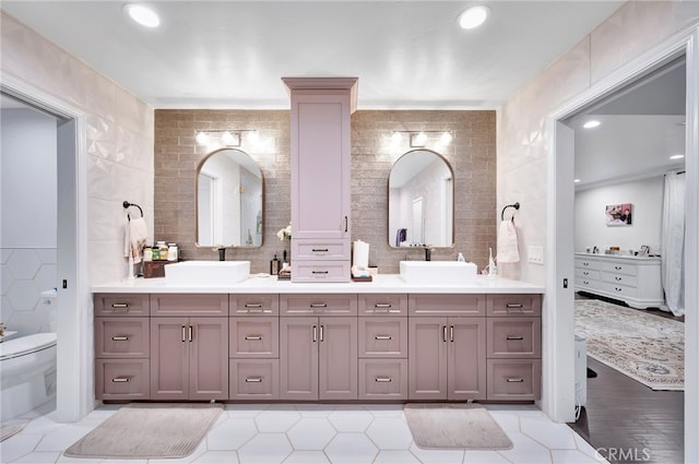 bathroom with tile walls, wood-type flooring, vanity, and toilet