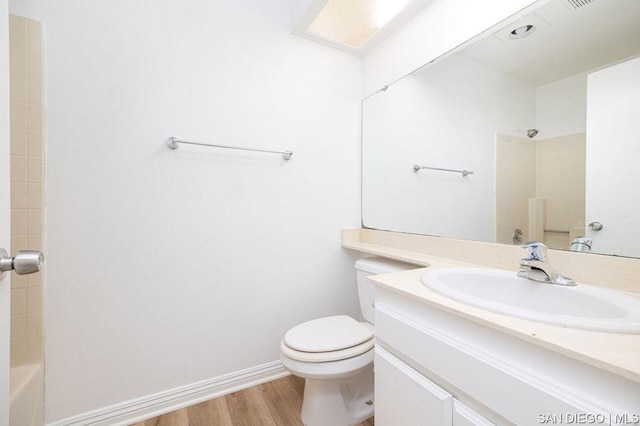 bathroom with toilet, vanity, and hardwood / wood-style flooring