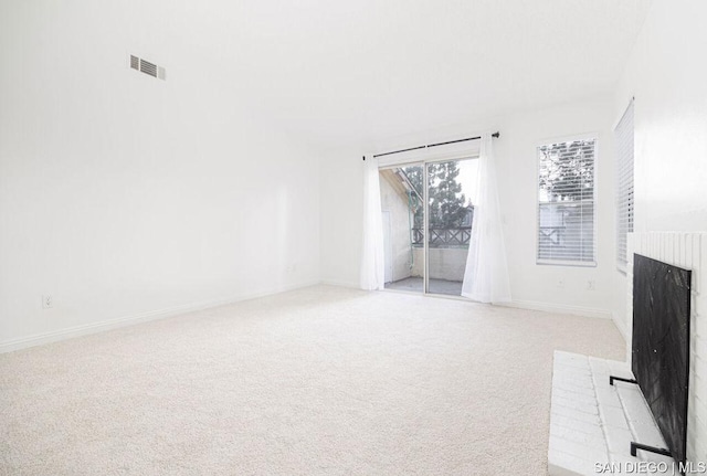 unfurnished living room with light carpet and a fireplace