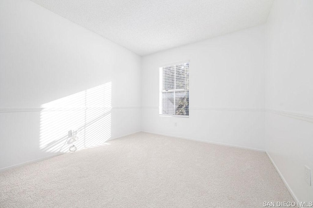 carpeted spare room featuring a textured ceiling