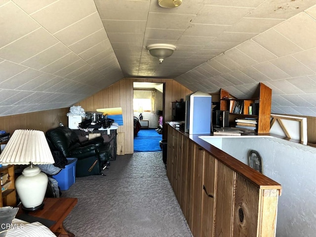 bonus room featuring lofted ceiling, wooden walls, and dark colored carpet