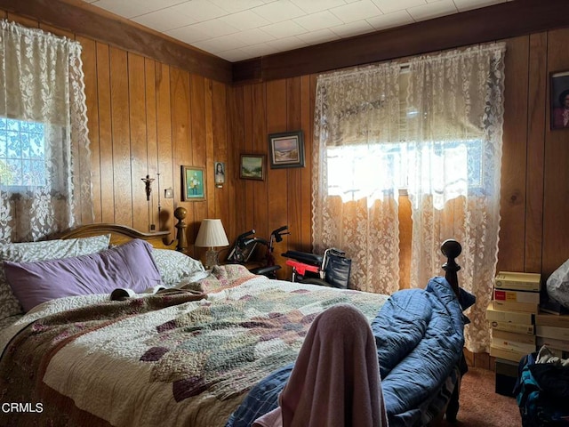 bedroom with wood walls and carpet flooring