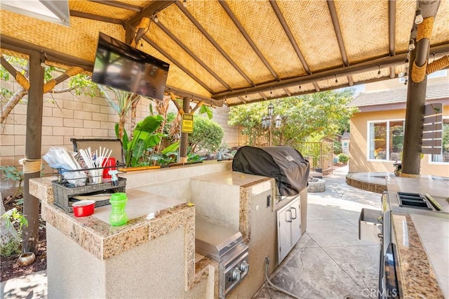 view of patio featuring a gazebo, an outdoor kitchen, and area for grilling