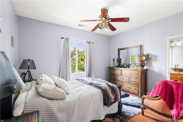 bedroom with ceiling fan, sink, and hardwood / wood-style floors