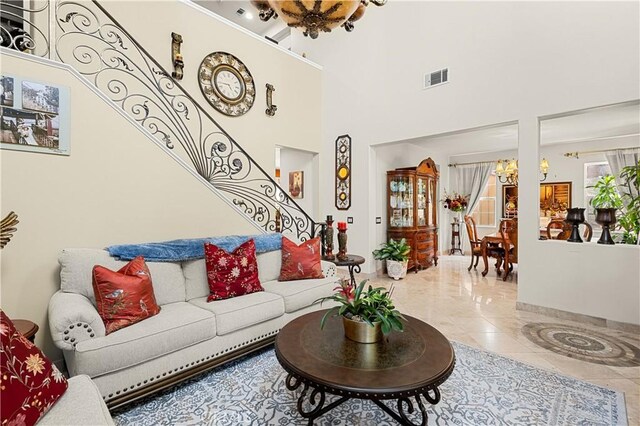 living room with tile patterned floors, a chandelier, and a high ceiling