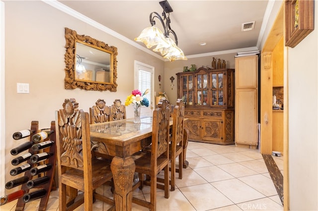 dining room featuring light tile patterned flooring and crown molding