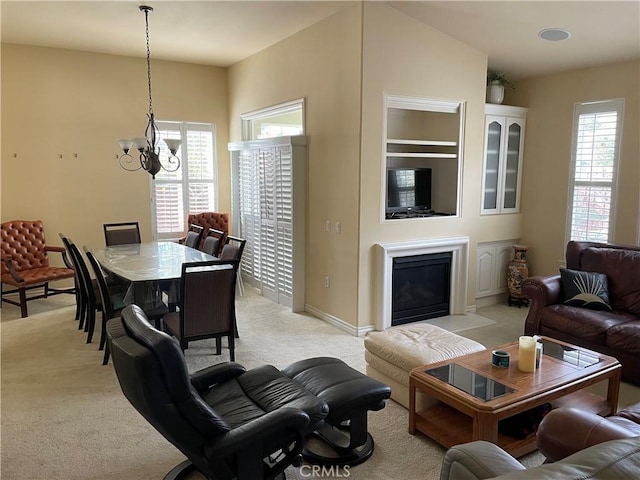 living room with light colored carpet, vaulted ceiling, and a notable chandelier