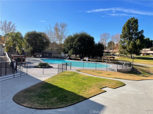 view of pool with a patio area and a yard