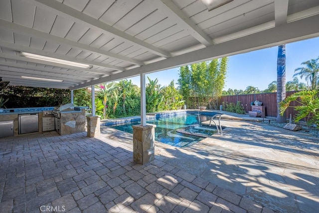 view of swimming pool featuring an outdoor kitchen, grilling area, and a patio area