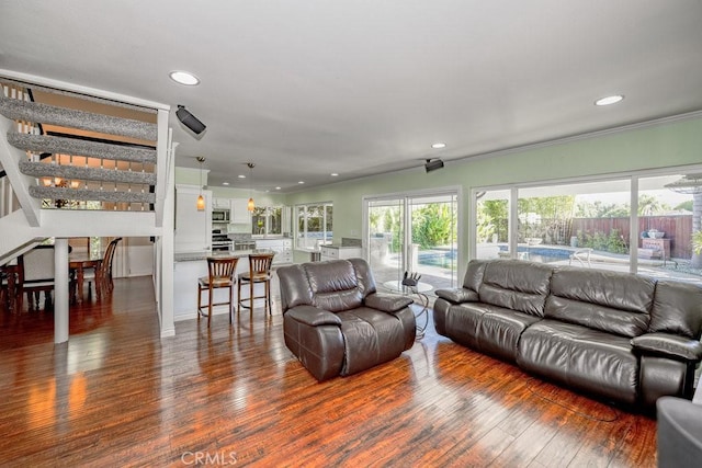 living room with dark hardwood / wood-style flooring and ornamental molding