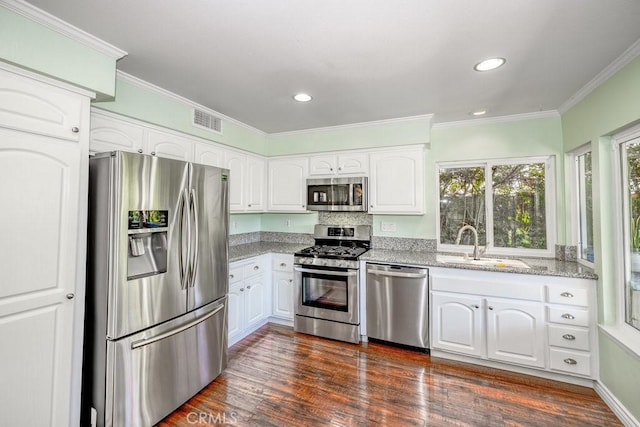 kitchen featuring dark hardwood / wood-style flooring, stainless steel appliances, and white cabinetry