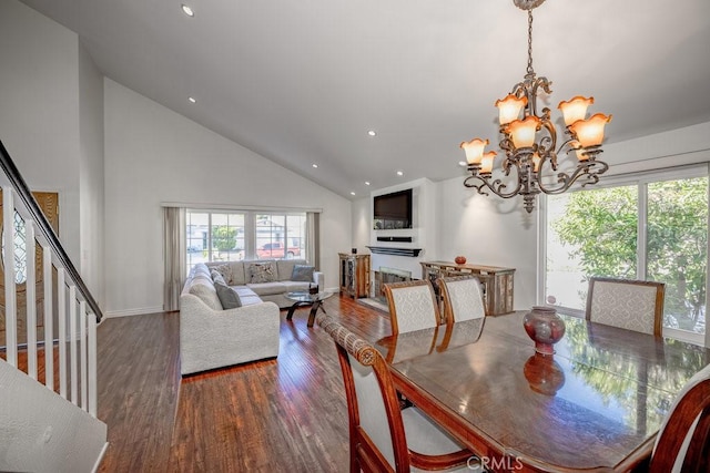 dining room with dark hardwood / wood-style flooring, high vaulted ceiling, and a notable chandelier