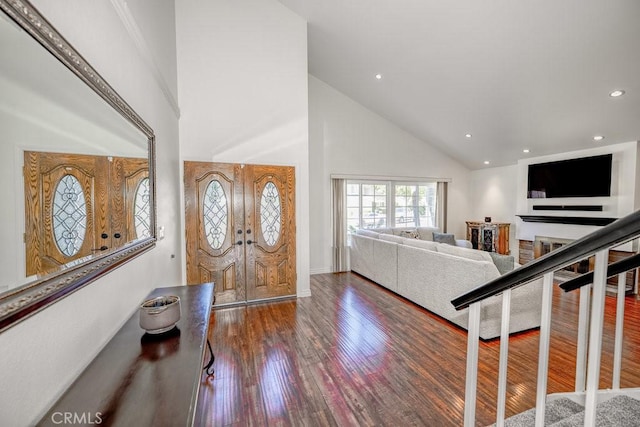 entryway with dark hardwood / wood-style flooring and high vaulted ceiling