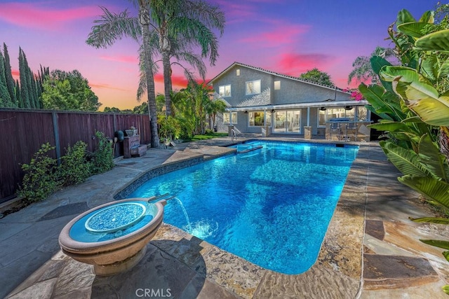 pool at dusk with a patio area