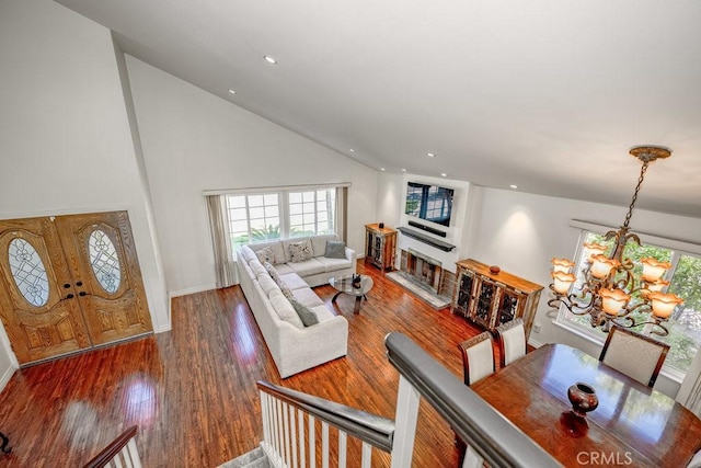 living room with dark hardwood / wood-style flooring, high vaulted ceiling, and a notable chandelier