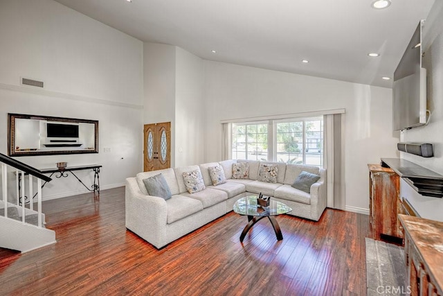 living room with hardwood / wood-style floors and high vaulted ceiling