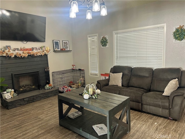 living room featuring wood-type flooring and a stone fireplace