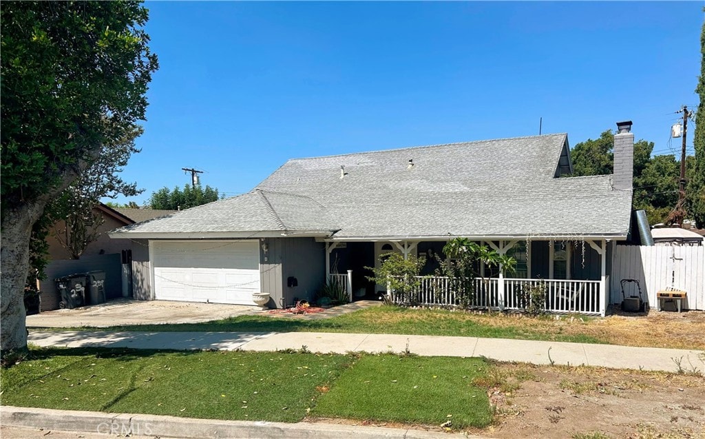 single story home with a front yard, a porch, and a garage