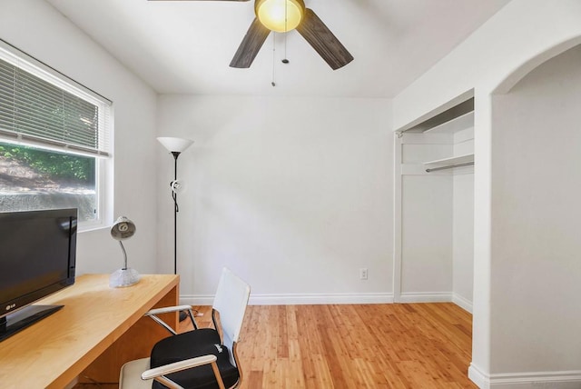 unfurnished office featuring light wood-type flooring and ceiling fan