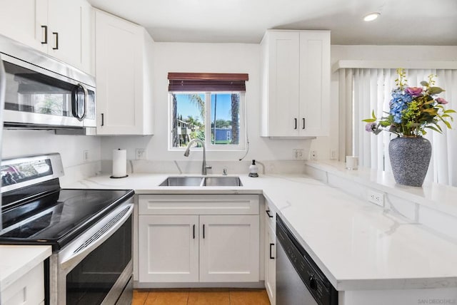 kitchen featuring stainless steel appliances, sink, and white cabinetry