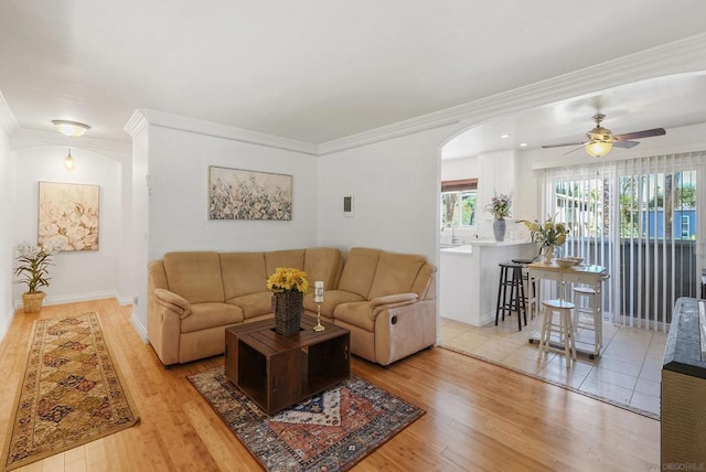 living room featuring ornamental molding, ceiling fan, and light hardwood / wood-style flooring